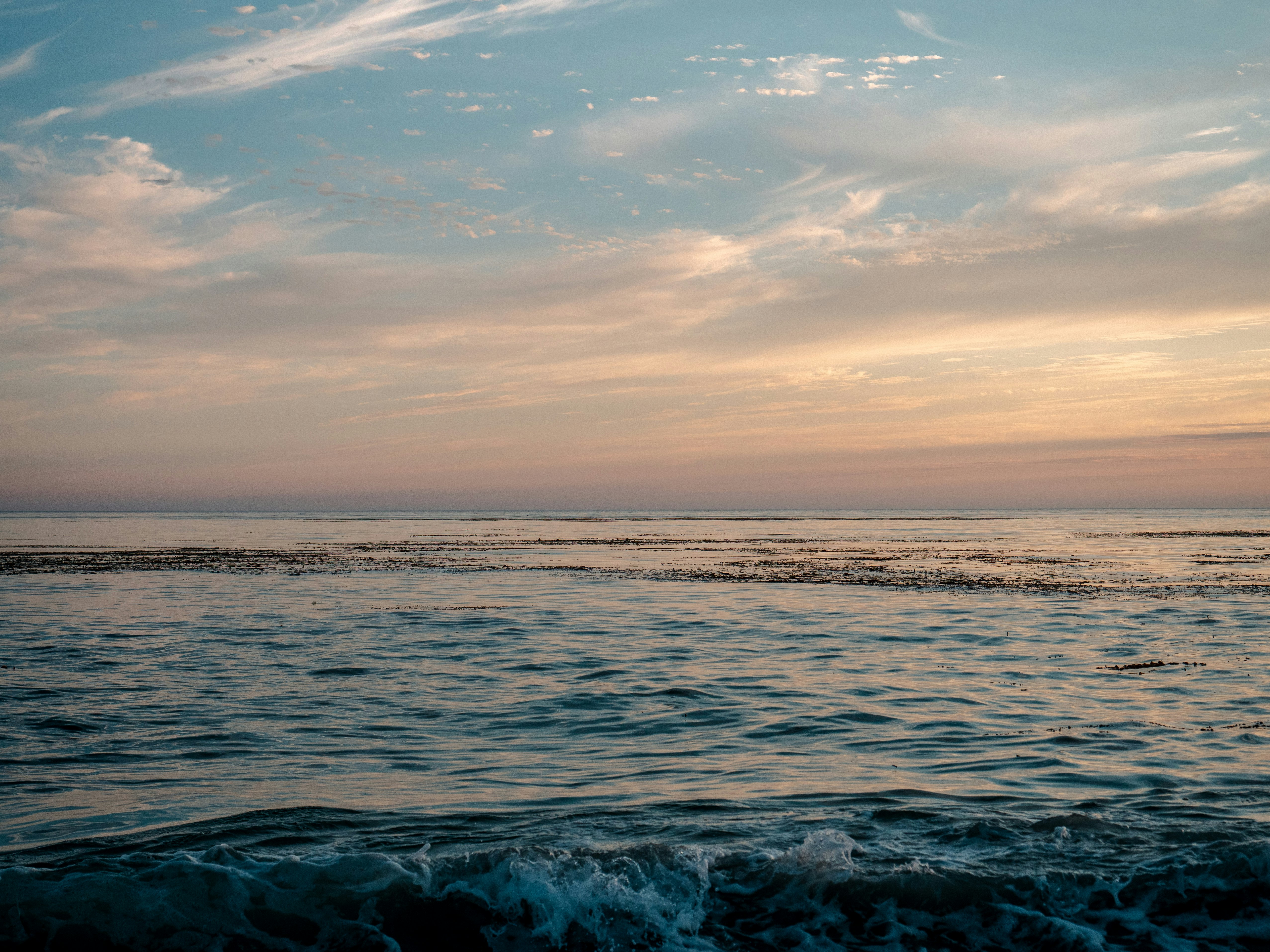 ocean waves under cloudy sky during daytime